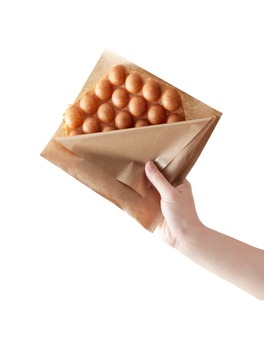 茶色の紙袋に入ったSoy storiesのワッフルを掲げて持っている手が伸びている。