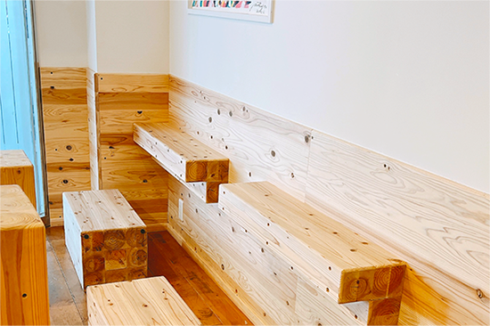 Soy storiesの店内。ベージュ色の木材と白い壁紙で、木でできた椅子や机が置かれている。