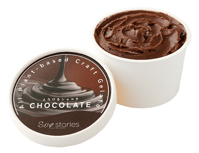 白い紙のカップに茶色のアイスクリームが入っている。その横には、チョコソースの写真と商品名が印刷されたカップアイスの蓋が置かれている。